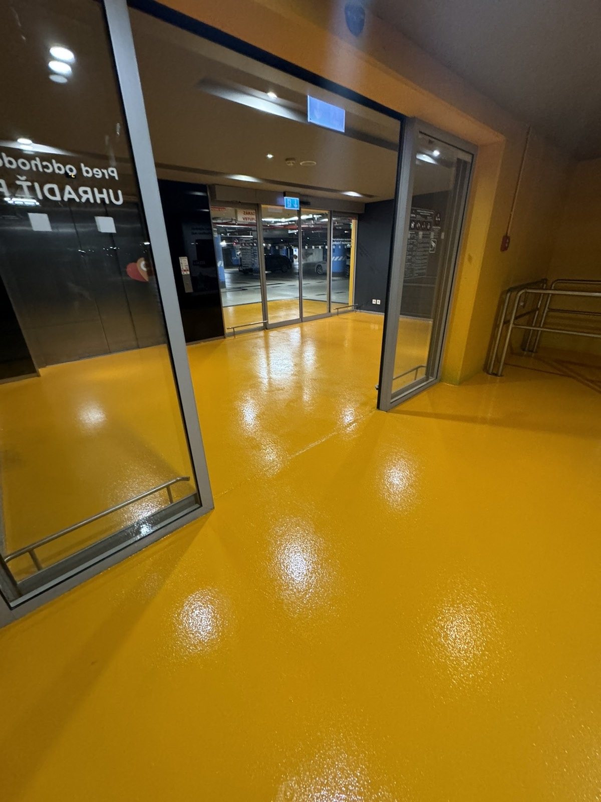 Nákupné centrum — vstupná zóna so žltou podlahou